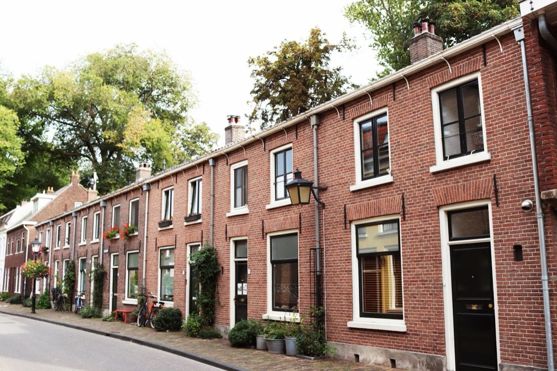 Rij bakstenen rijtjeshuizen in een Nederlandse straat